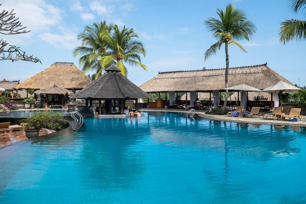 A luxury tropical resort with a swim-up bar and palm trees — the kind of escape that fades when Monday arrives